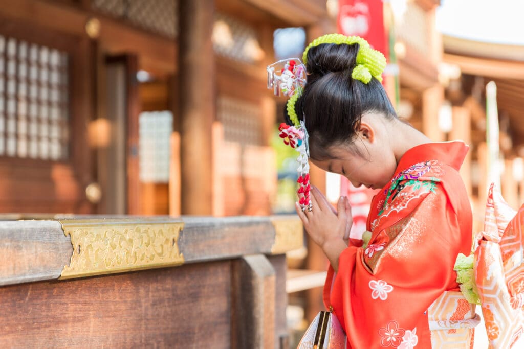 赤いお着物で手を合わせる七五三の女の子