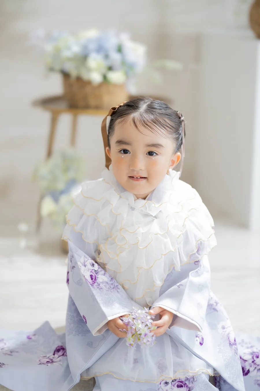 花を手に微笑む3歳の女の子