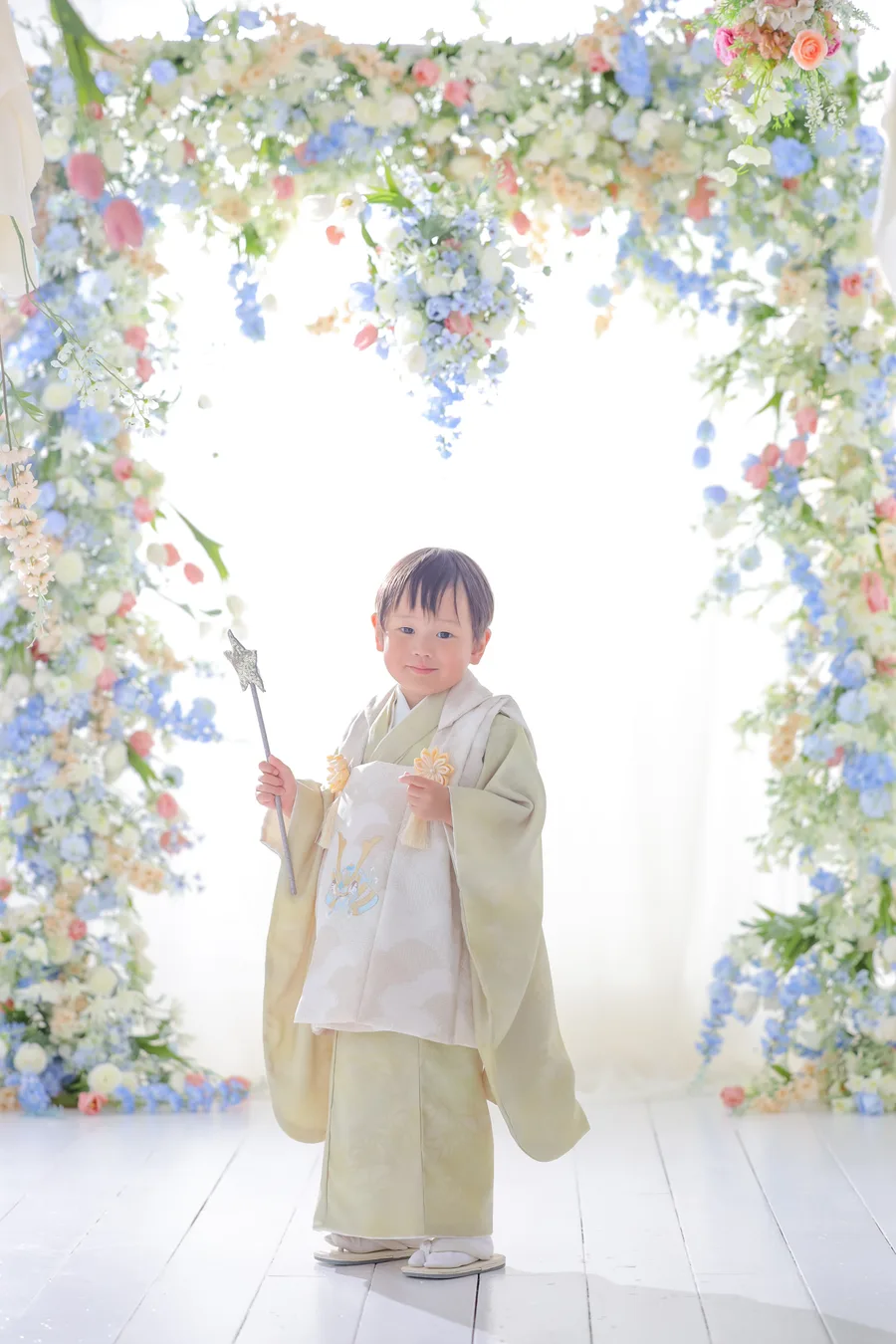 若草色の被布で破魔矢を持つ3歳の男の子