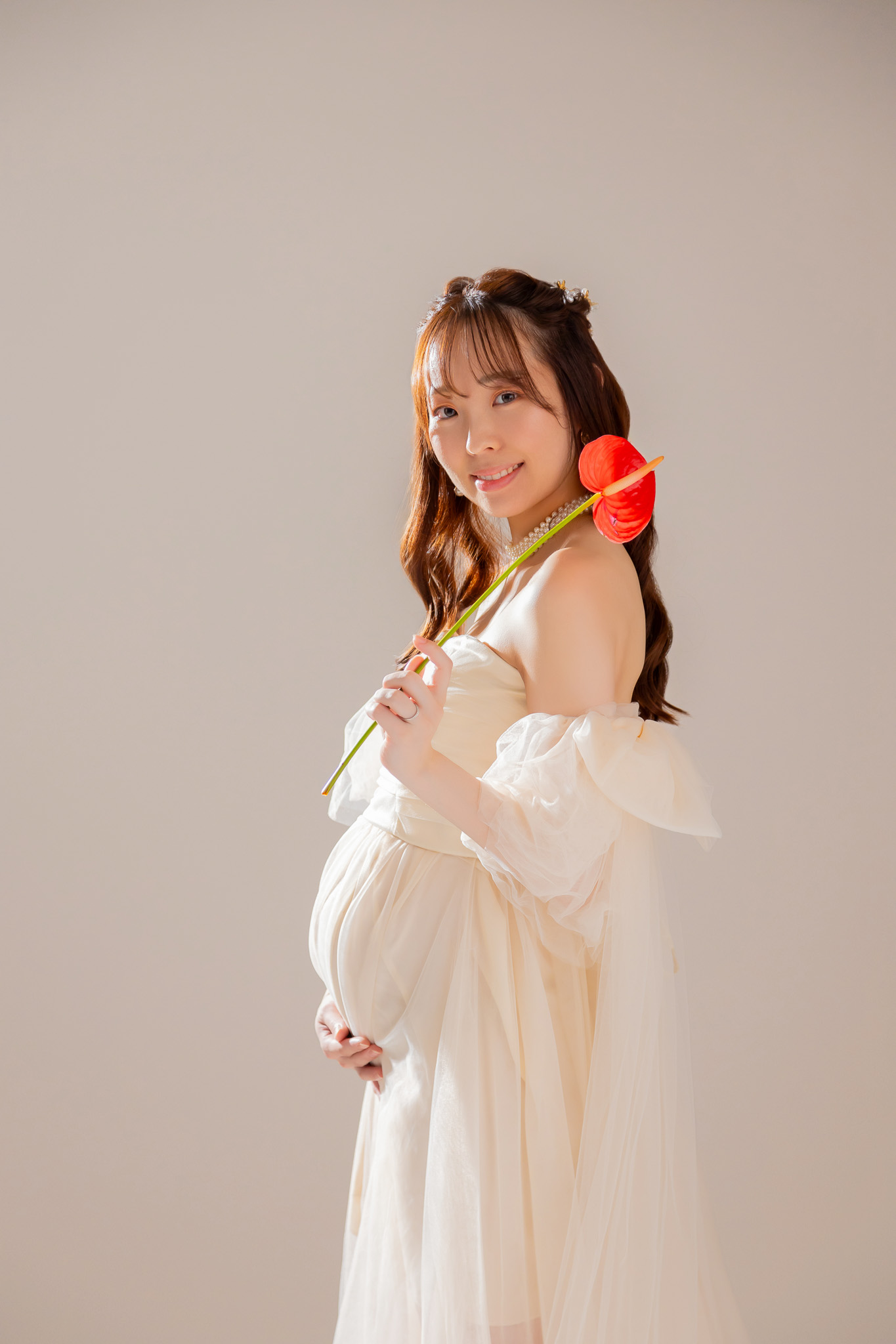 メイクとヘアを仕上げ、花を手にして微笑む横顔