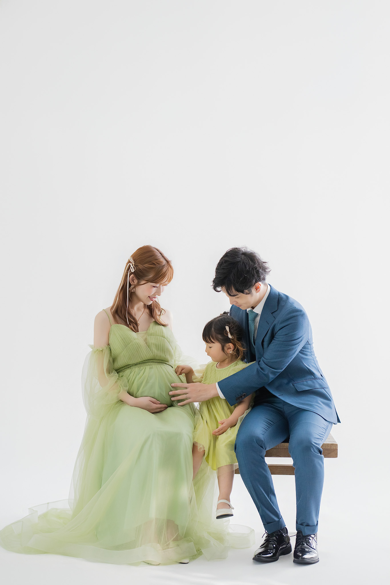 ベンチに腰かけ、上の子を囲んで並ぶご家族