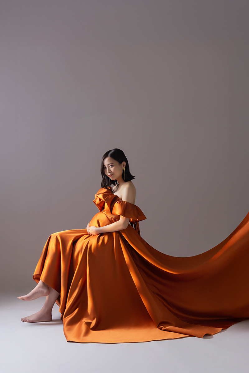 グリーンのマーメイドドレス、花束を手に