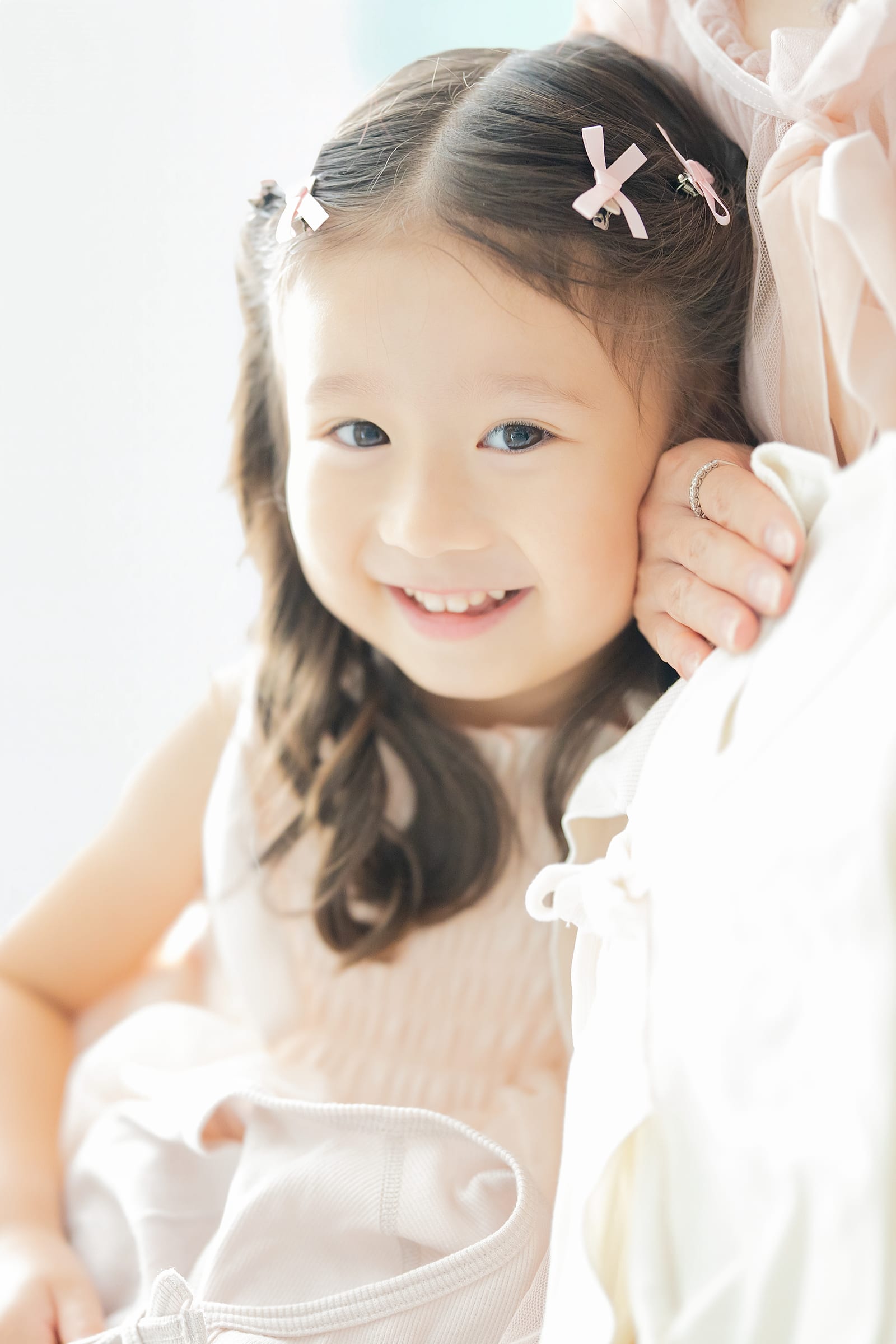 母に寄り添い、こちらへ微笑む上のお子さま