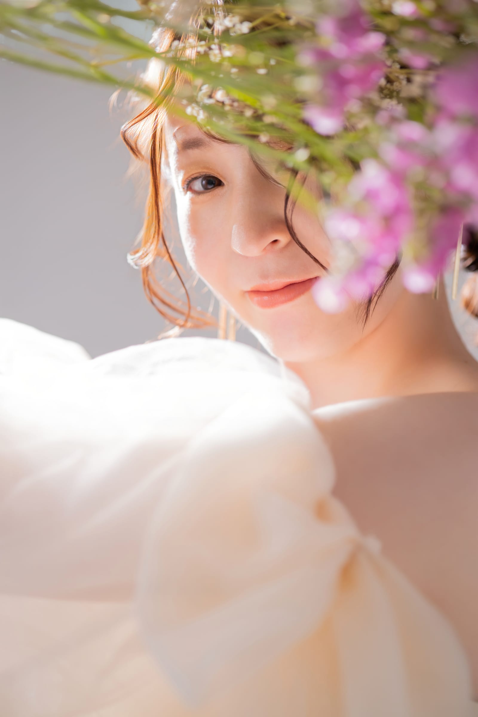 花を髪に飾り、やわらかな光の中で微笑む妊婦の寄り